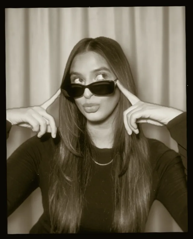 A sepia print of a woman in sunglasses, with a black border